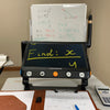 CloverBook Pro being used in a classroom setting to scan aa math paper. The text on screen is in yellow and the background is black.