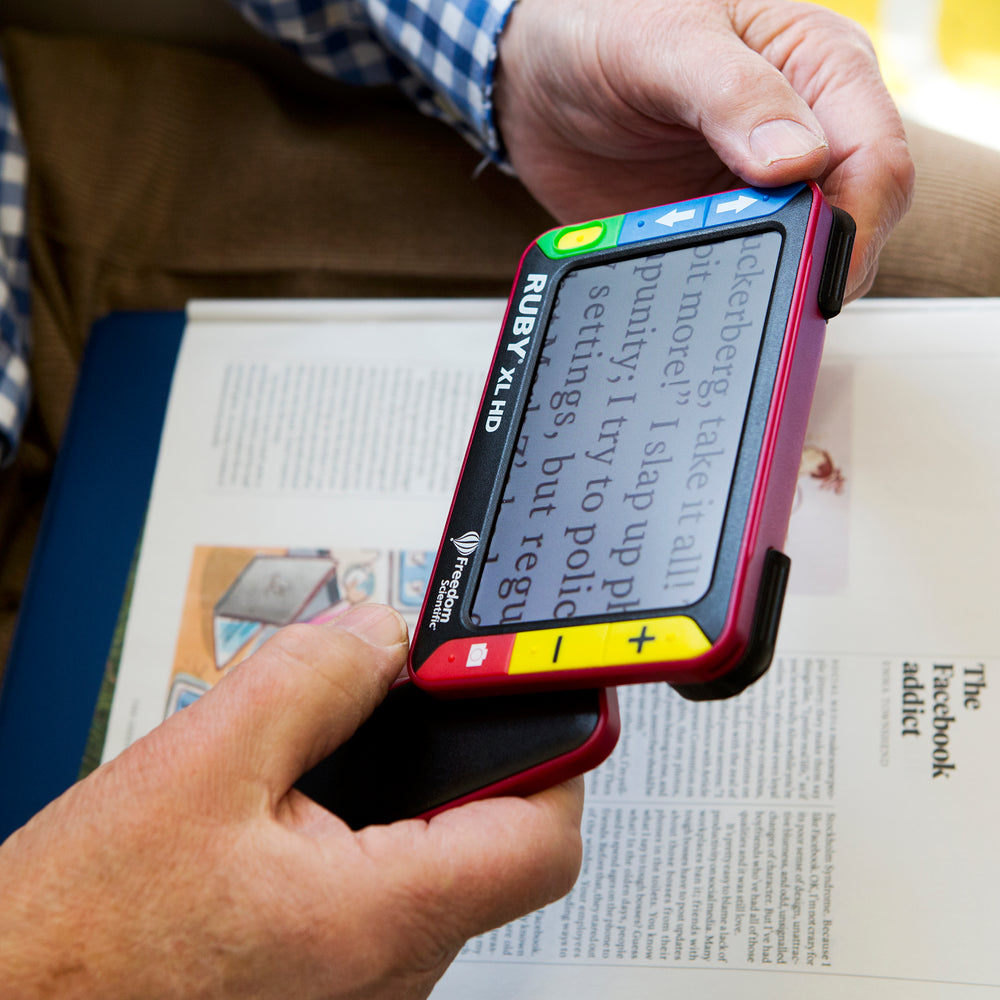 Someone using the magnifier to read a magazine