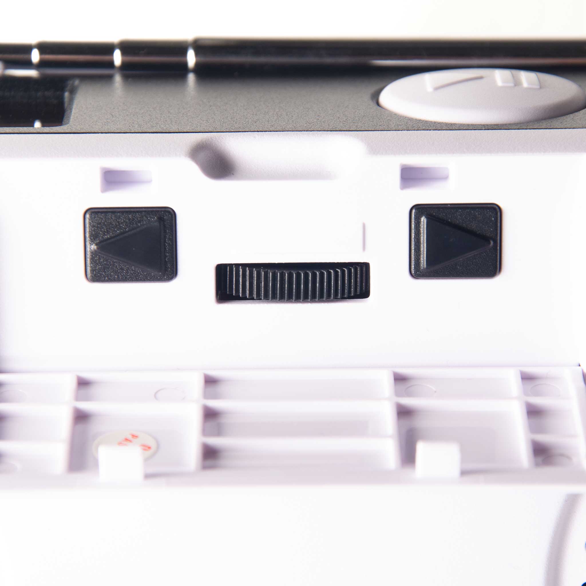Close-up of radio control panel with two black directional buttons and a small black slider switch.