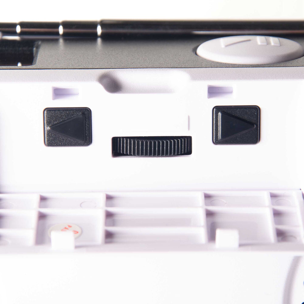 Close-up of radio control panel with two black directional buttons and a small black slider switch.