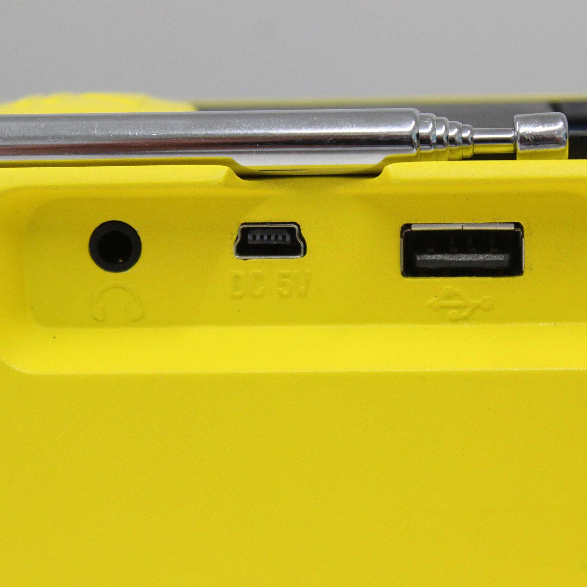 Close-up of a yellow radio with USB and DC 5V ports.