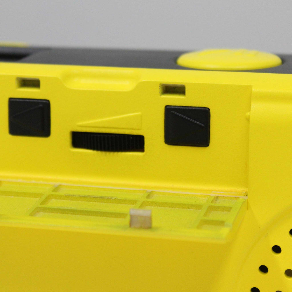 Close-up of a yellow and black electronic radio with a gray background