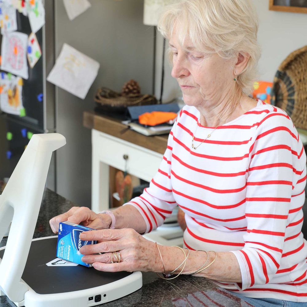 Woman using the Hark AI Reader to scan a box of medicine