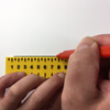 Someone using the tactile ruler to draw a line