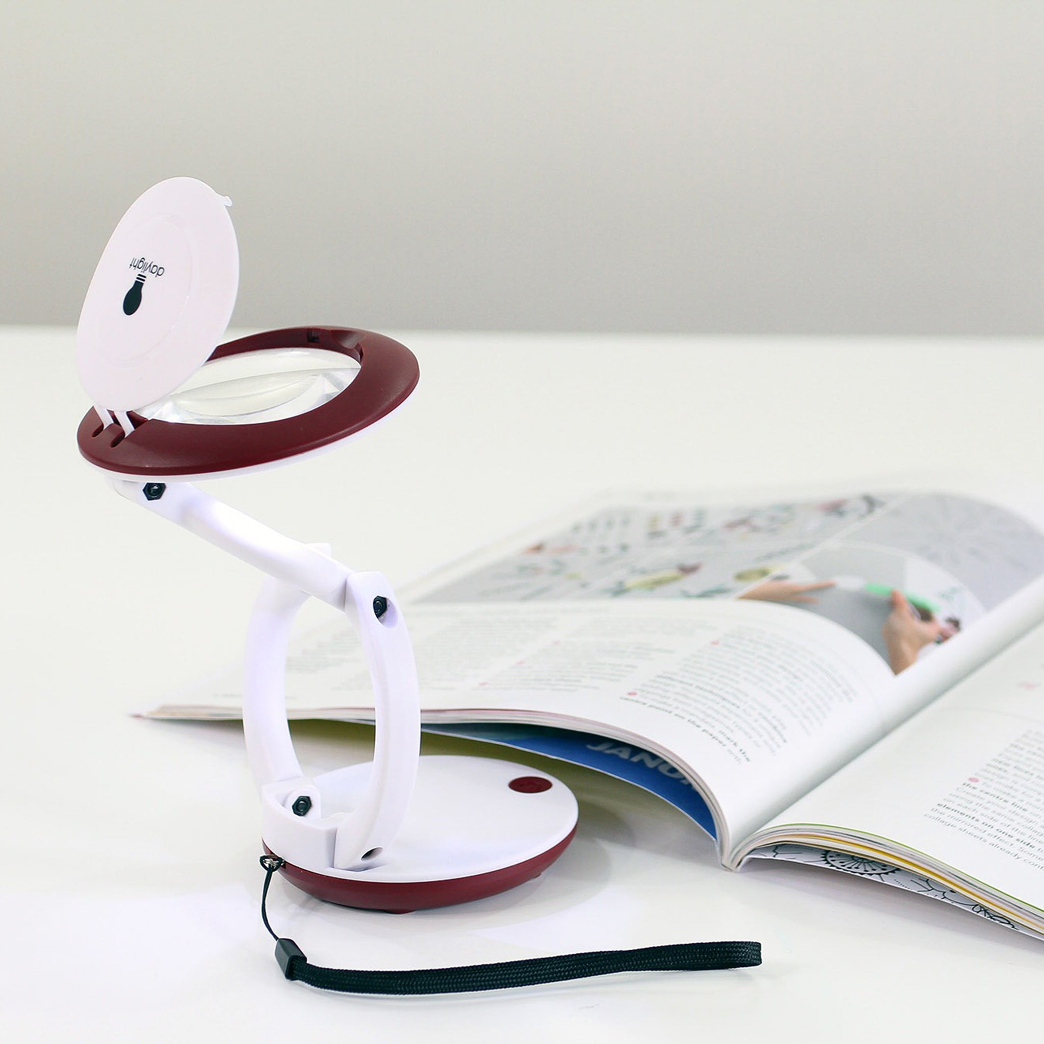 Magnifier nearly fully extended, positioned next to a magazine