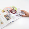 Magnifier opened to show magnifying lens on a magazine
