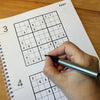Person solving a Sudoku puzzle.