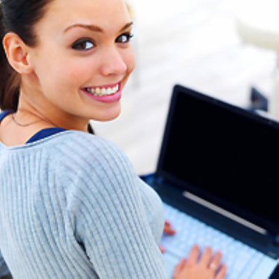 Young adult sitting with an open laptop