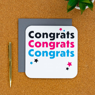 Congratulations card on a desk with pen next to it