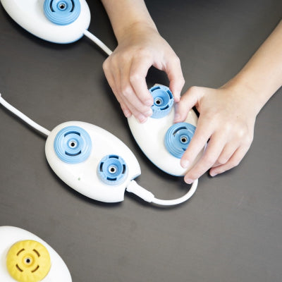 Child's hand turning the dials on the Play pod.