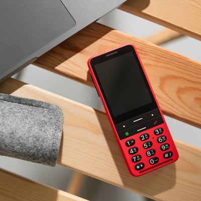 Image shows red BlindShell on wooden bench next to a laptop