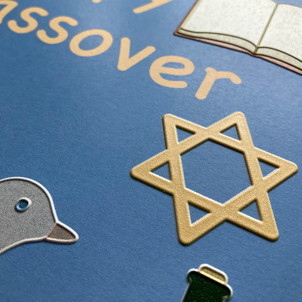 Passover card close up with a Star of David, dove, and book on a blue background.