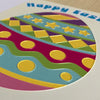 Colorful Easter egg design with geometric patterns on a card, featuring the text 'Happy Easter'.