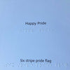Text inside the card with 'Happy Pride' and 'Six stripe pride flag' on a blue background with braille text.