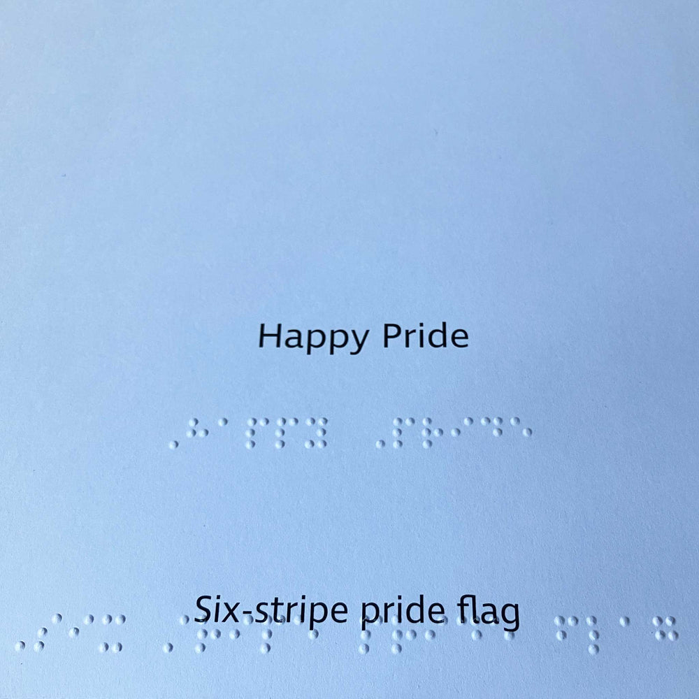 Text 'Happy Pride' and 'Six-stripe pride flag' on a white background with braille text.