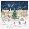 A festive illustrated winter village scene with colorful houses, a decorated Christmas tree, small people walking and gathering, shooting stars in the night sky, and the words 'Happy Christmas' at the bottom.