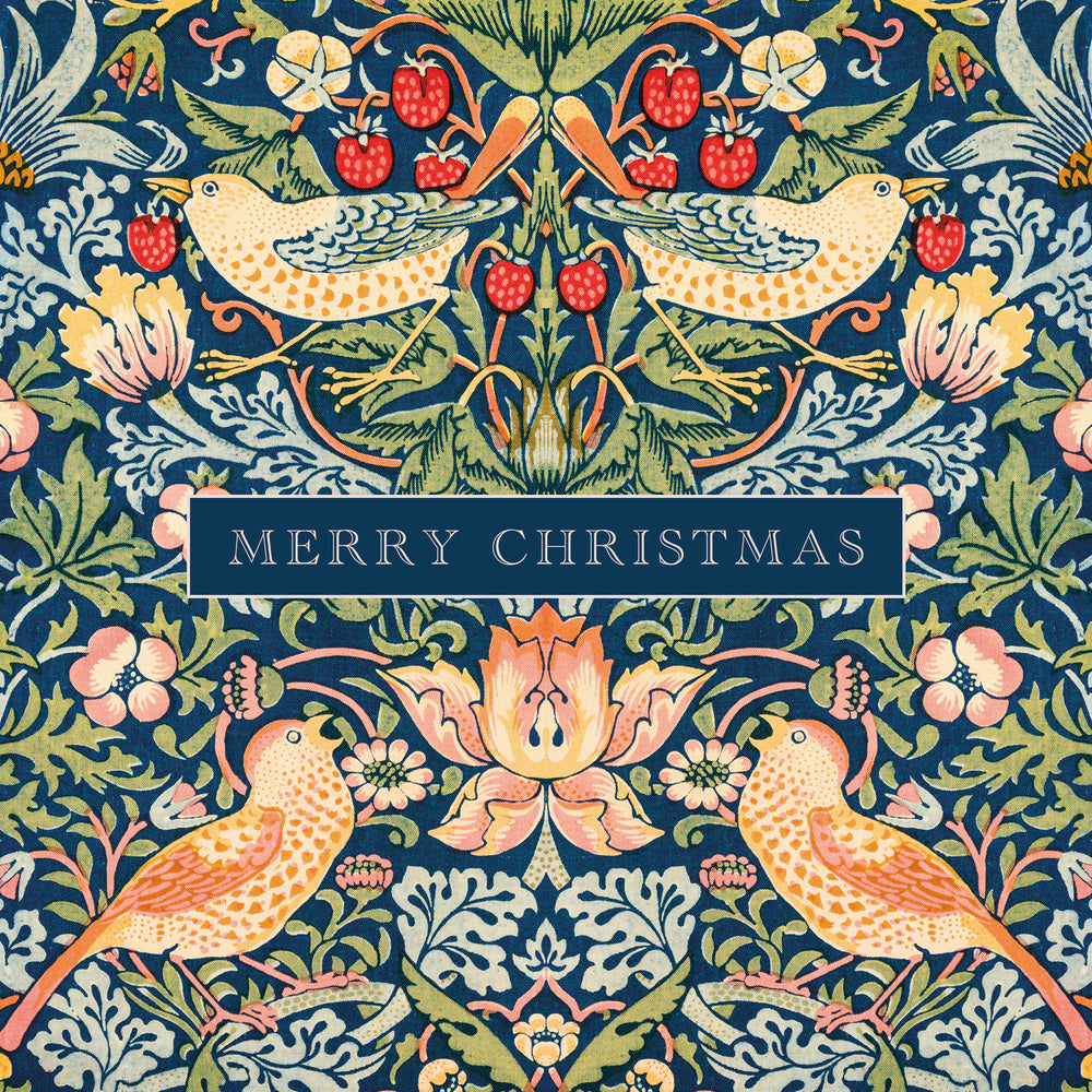 A festive Christmas illustration featuring a symmetrical William Morris-style pattern with two birds, flowers, leaves, and red berries on a dark blue background, with a central banner reading “MERRY CHRISTMAS.”.