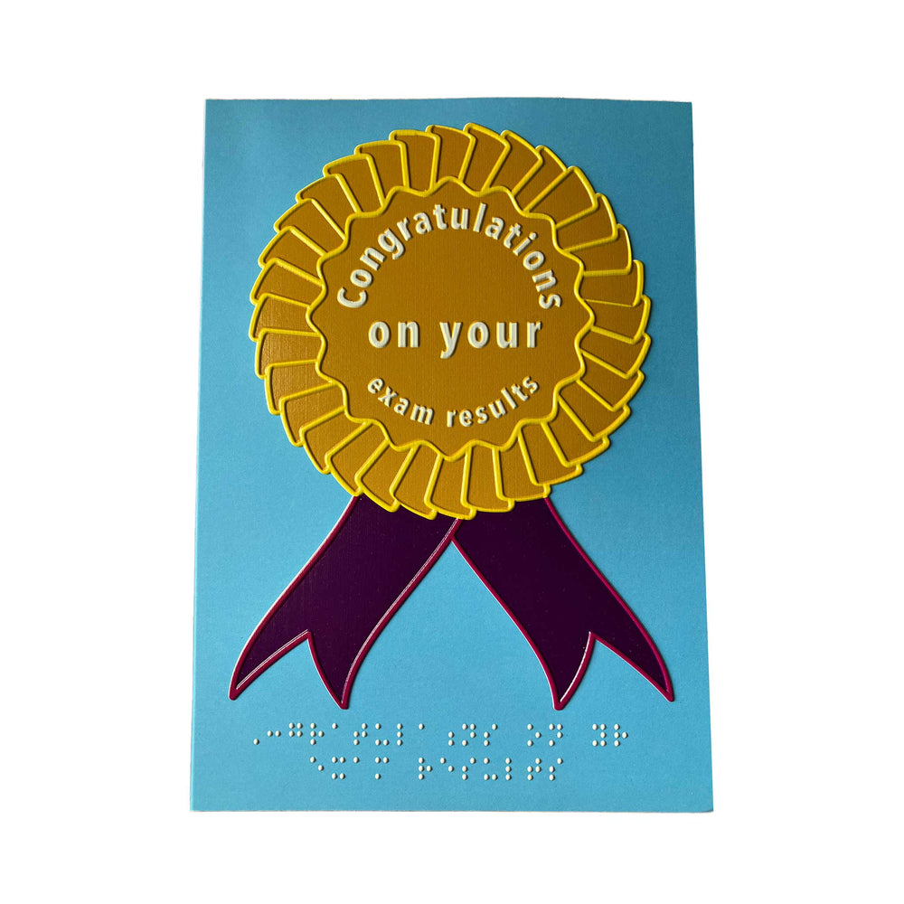 Pale blue card with golden yellow rosette with purple ribbons. Message in white text and braille reads 'Congratulations on your exam results'