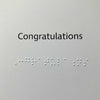Congratulations message printed in black text with braille letters underneath.