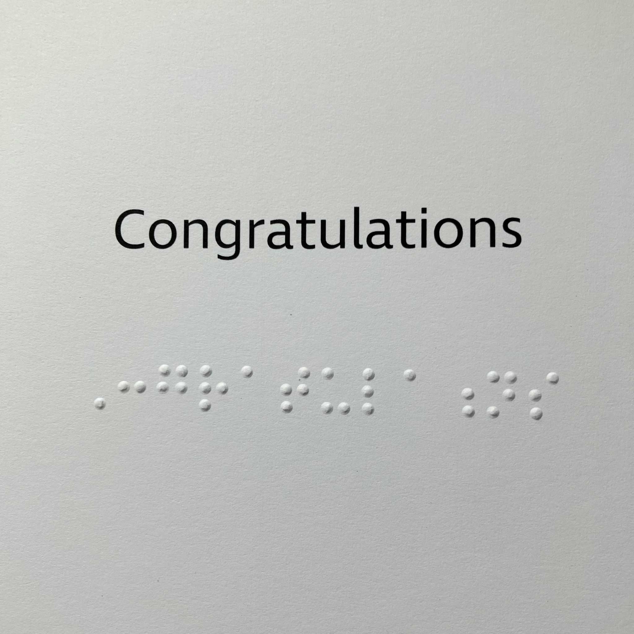 Congratulations message printed in black text with braille letters underneath.