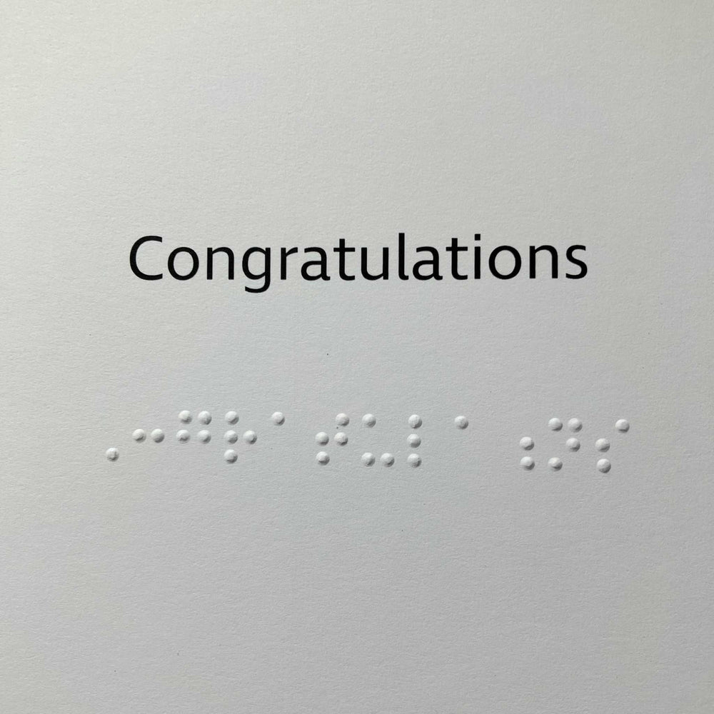Congratulations message printed in black text with braille letters underneath.