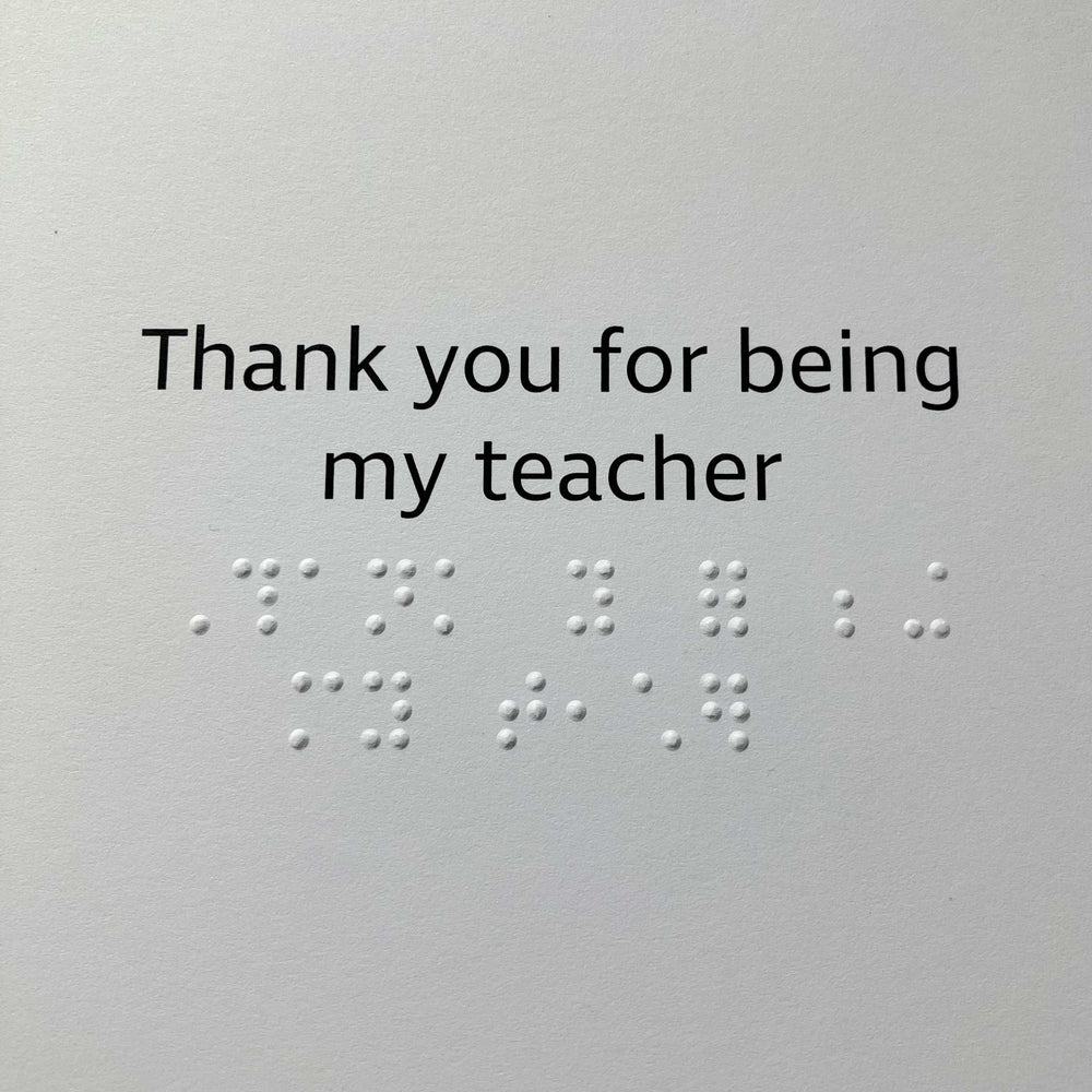 Card with the phrase 'Thank you for being my teacher' in black text with braille text, shown against a plain white background.