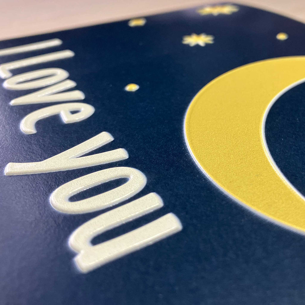Card with 'I love you' text and a yellow crescent moon on a blue background