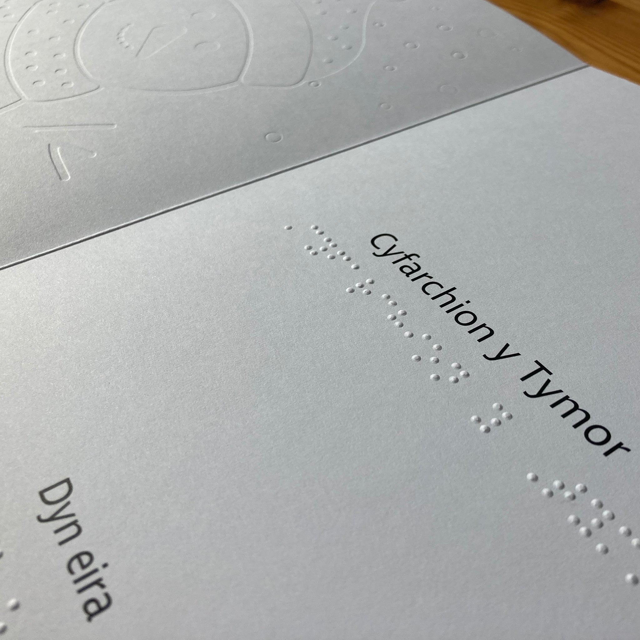 Message inside card in print and braille that reads Cyfarchion y Tymor