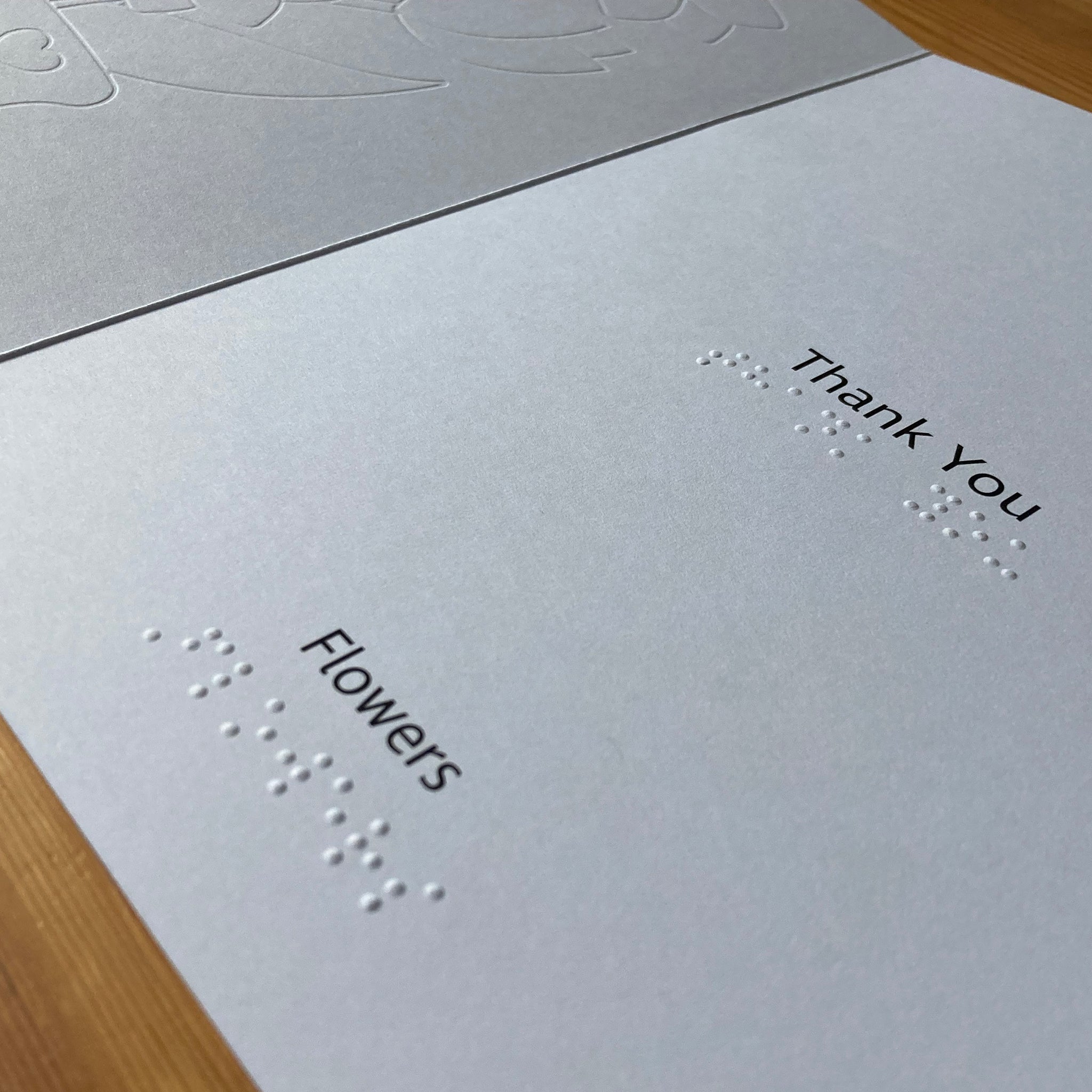 Inside of inclusive thank you card with 'thank you' and 'flowers' in large print and braille.