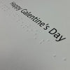 Close-up of large print and braille 'Happy Galentine's Day' greeting inside the card.