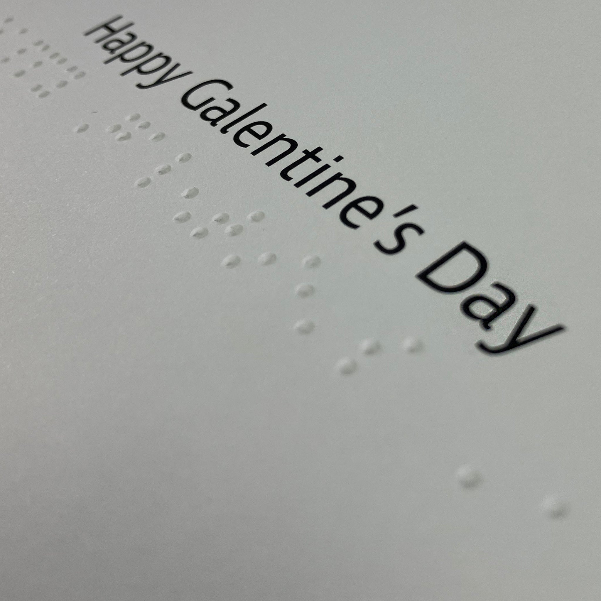 Close-up of large print and braille 'Happy Galentine's Day' greeting inside the card.
