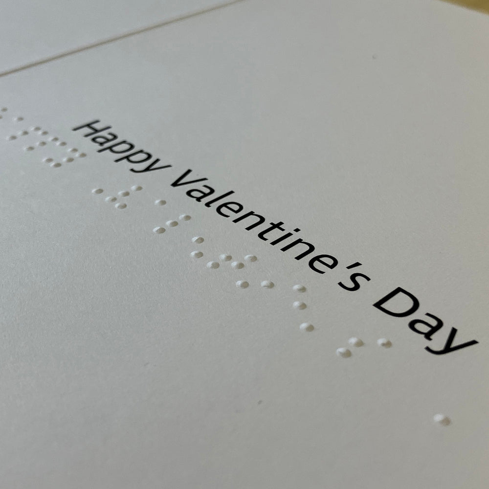 Close-up of large print and braille 'Happy Valentine's Day' message inside card.