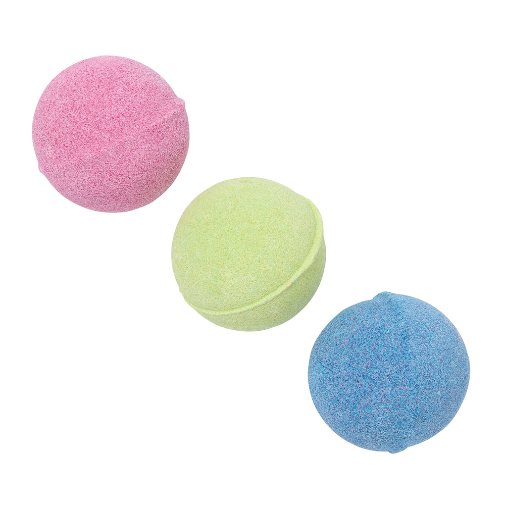 Three colorful bath fizzers in pink, green, and blue on a white background