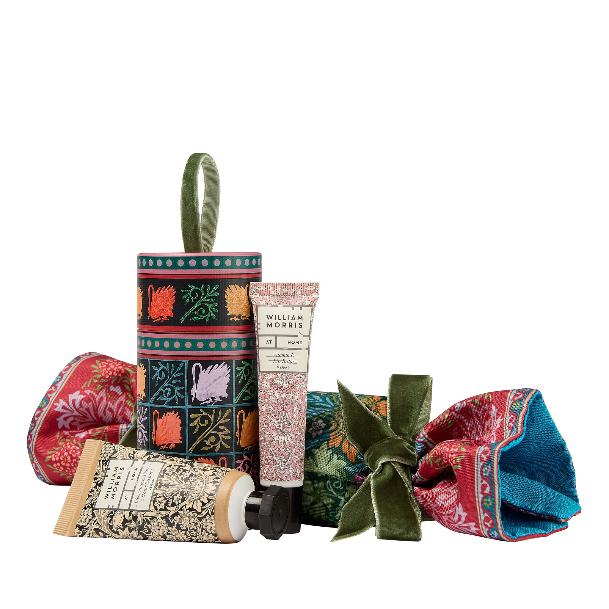 Collection of decorative items including a cylindrical box, a tube of cream, and a folded fabric with floral patterns on a white background.