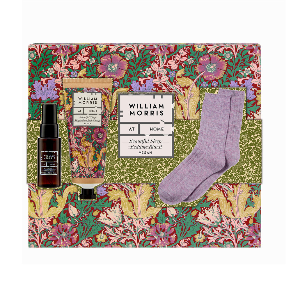 Gift set with body cream, pillow mist, and socks on a decorative box with floral design.