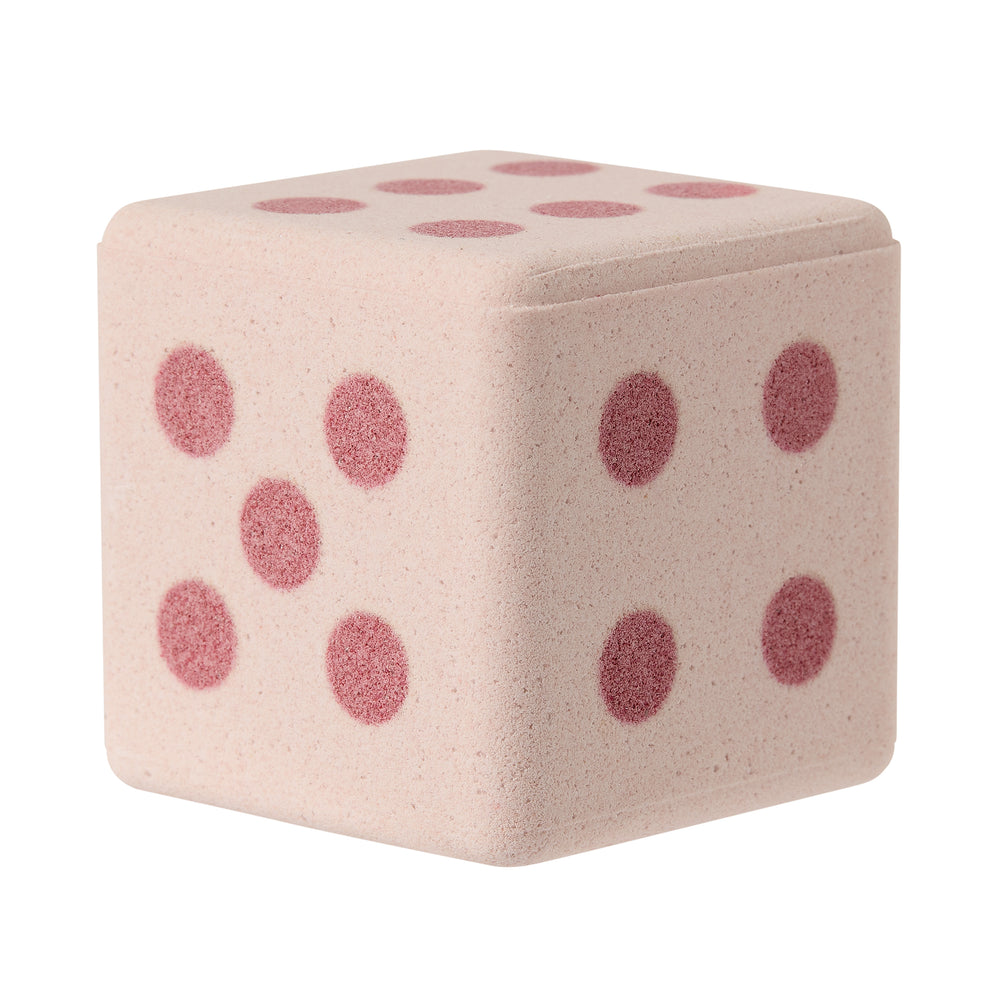 Pink dice-shaped bath bomb on a white background