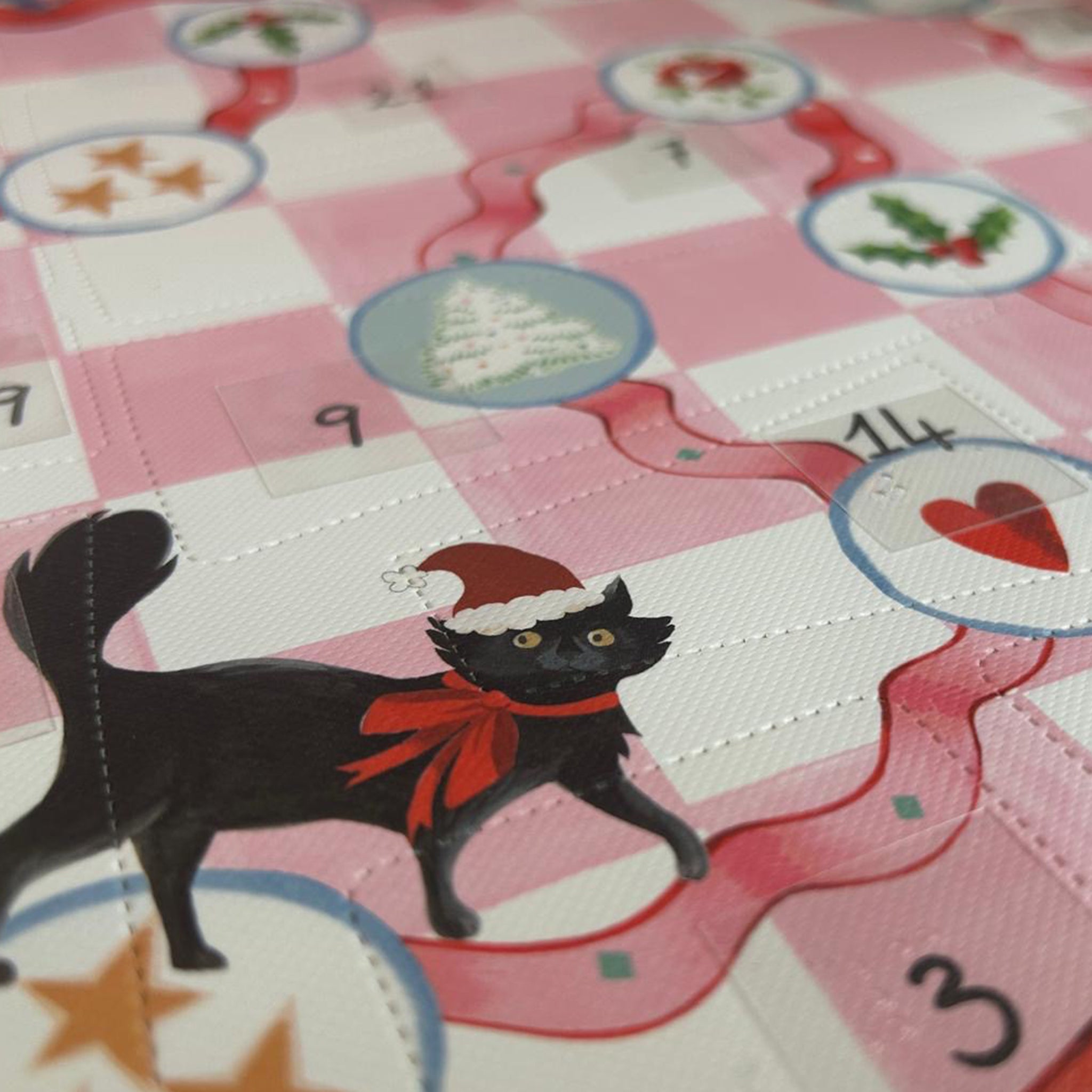 Close up off Cath Kidston beauty advent calendar showing advent windows and a black cat with a christmas hat on.
