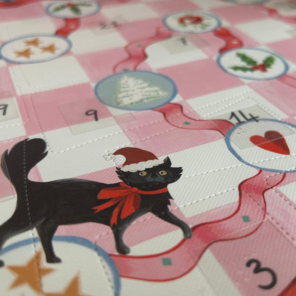 Close up off Cath Kidston beauty advent calendar showing advent windows and a black cat with a christmas hat on.