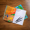 Children's activity book with coloring page and markers on a wooden surface
