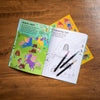 Coloring book with a coloring page and markers on a wooden surface