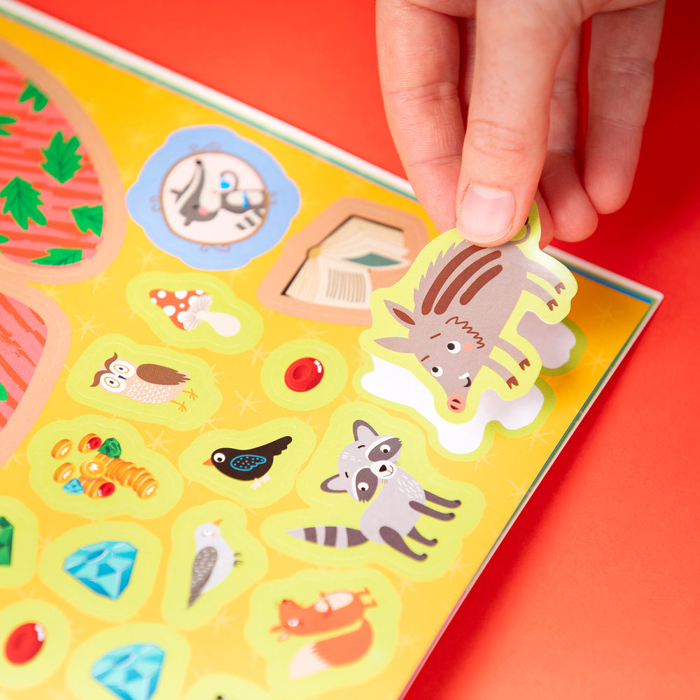Hand placing a sticker of a warthog onto a colorful board game with animal illustrations.