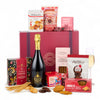 Gourmet gift basket with champagne, snacks, and cookies on a white background