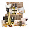 Gourmet gift basket with wine, chocolate, and other treats on a white background