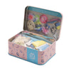 Open tin box with fairy-themed toys and accessories on a white background