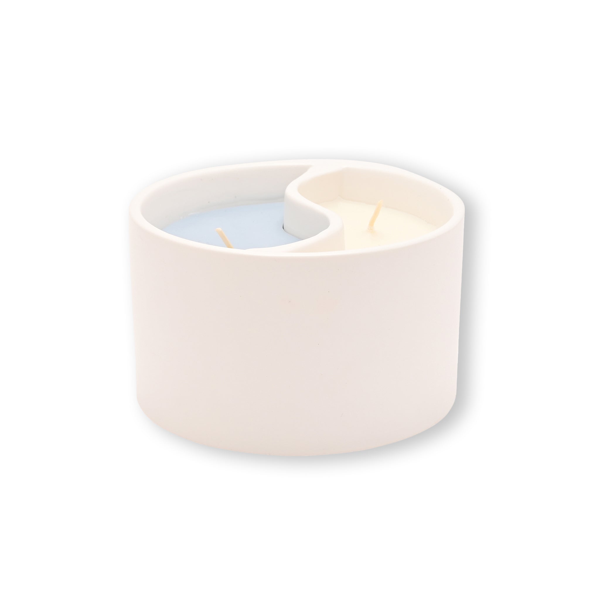 White ceramic candle holder with a blue  and white candles in a yin yan design on a white background