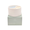 Candle in a white holder on a green box with 'Serenity' branding