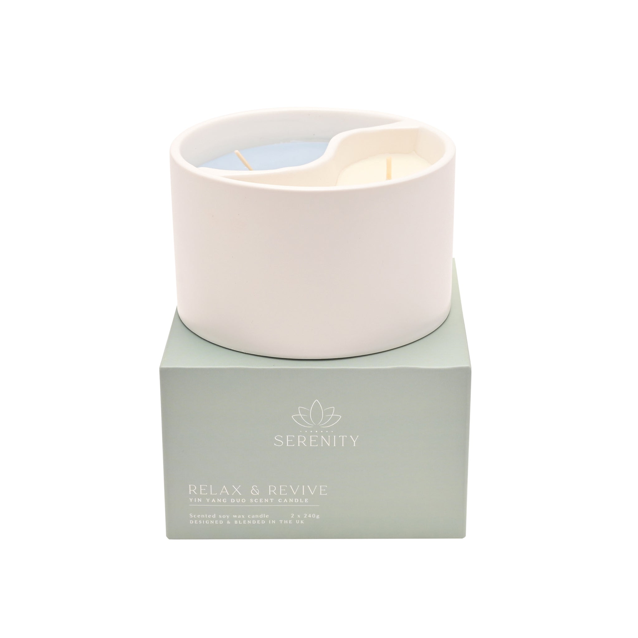 Candle in a white holder on a green box with 'Serenity' branding