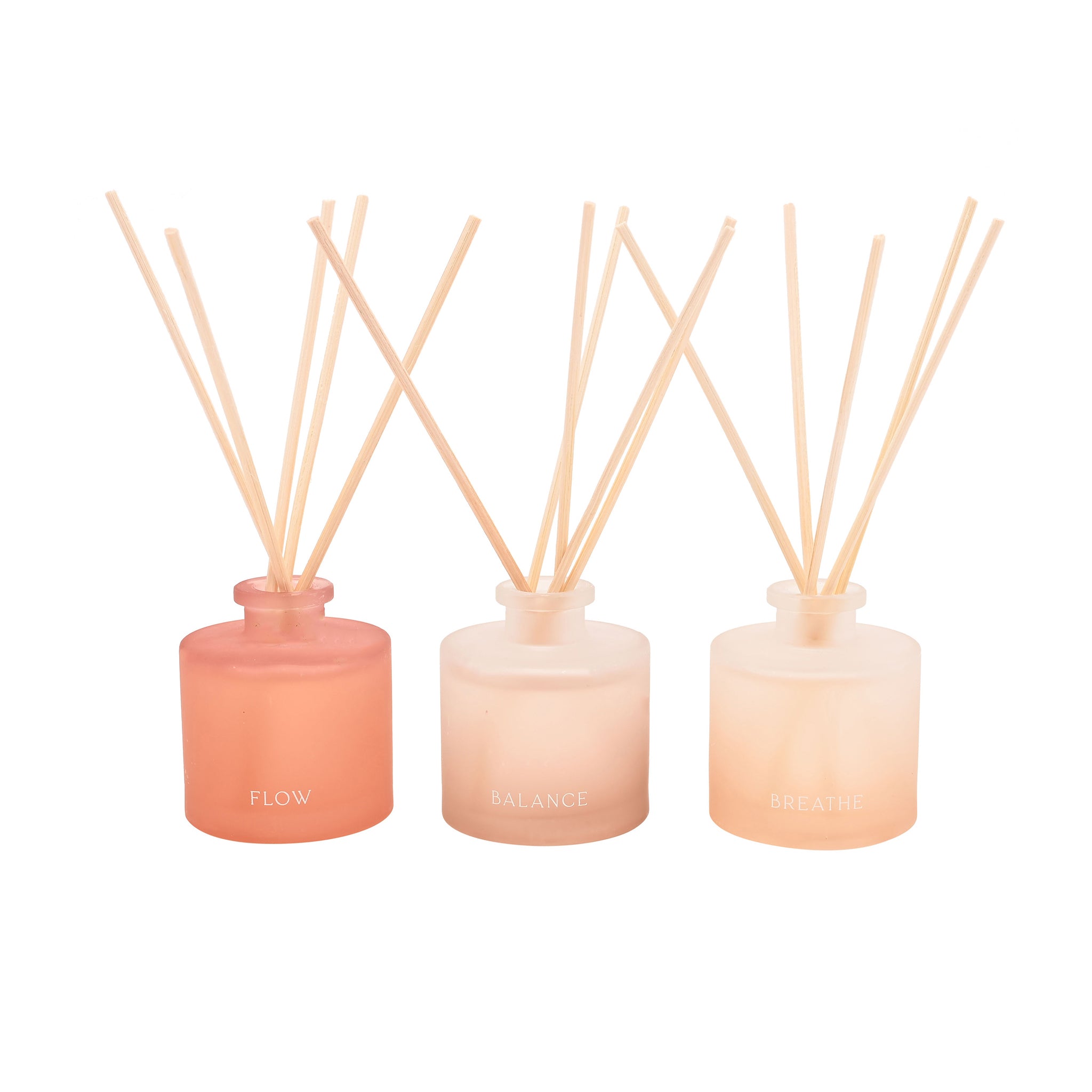 Three diffuser bottles with wooden sticks on a white background