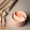 Pink candle holder with two candles on a neutral background
