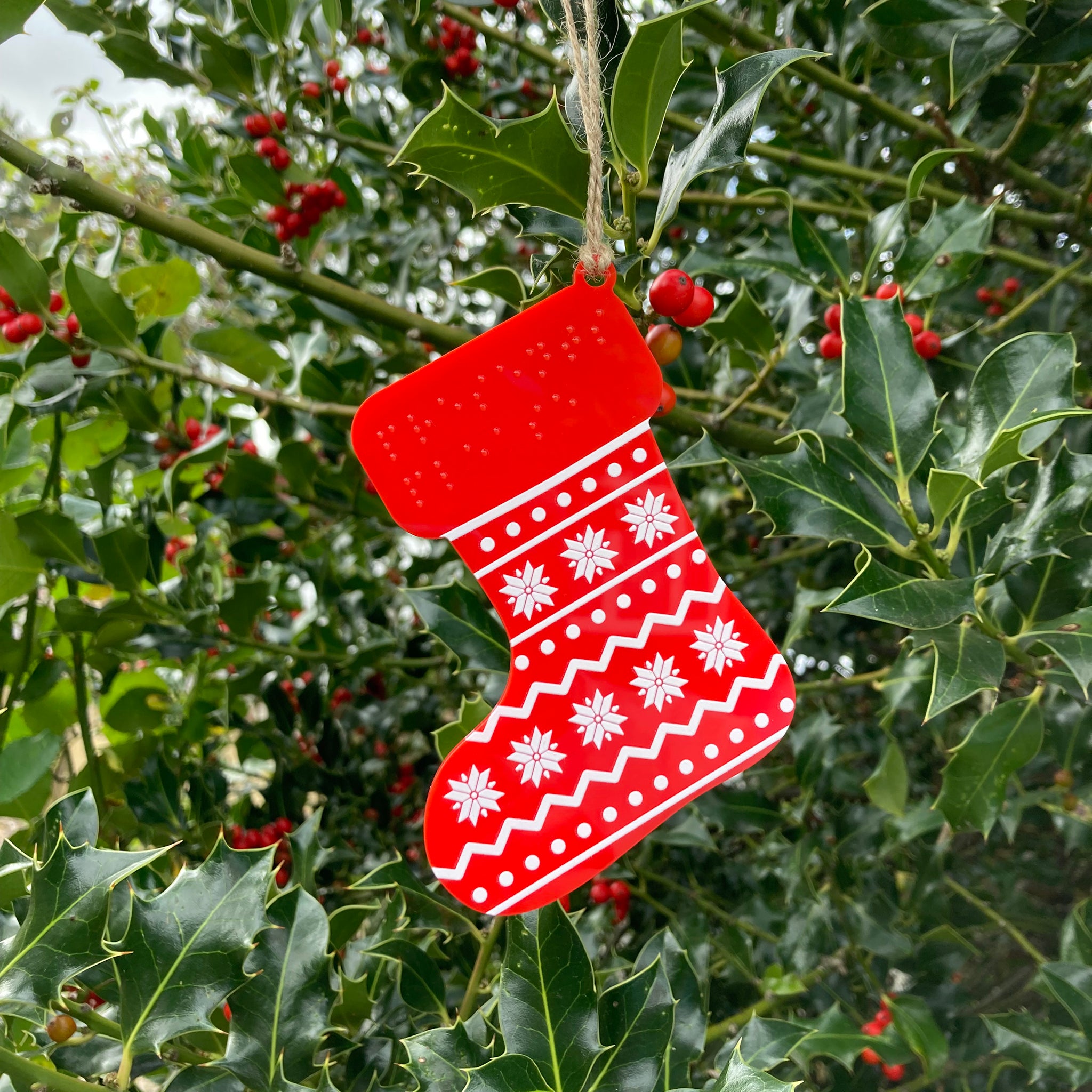 Red and white Christmas stocking tree decoration hanging on a tree. 